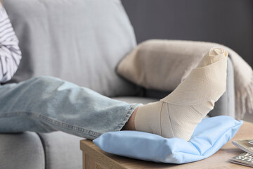 Young woman with injured foot after accident at home, closeup