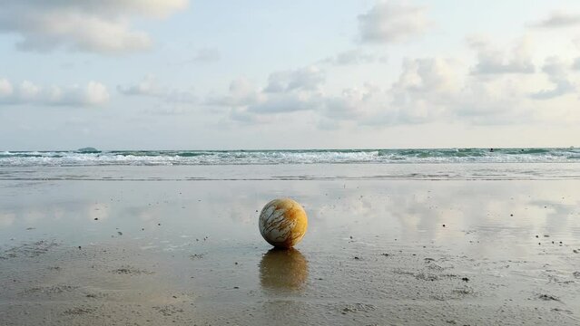 beach landscape with a soccer ball on the sand under a summer sun	
