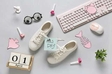 Shoes with tied laces, computer keyboard and calendar on white background. April Fools Day prank