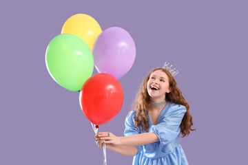 Young redhead woman in crown with balloons on lilac background