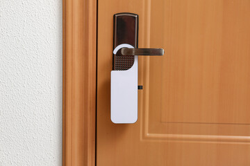 Modern wooden door with white hanger in hotel room