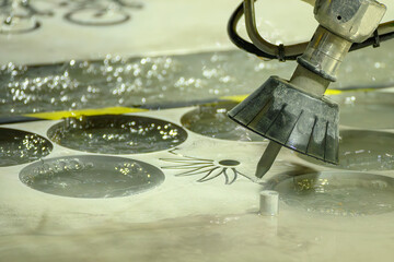 The multi axis abrasive waterjet cutting machine cutting the metal plate in the light blue scene.