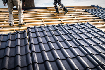 Professional masters (roofer) covers repairs metal roof tile