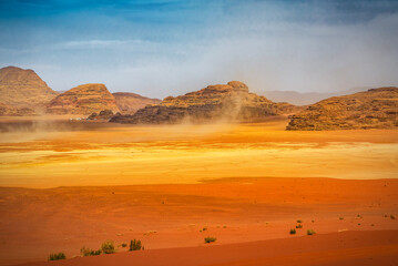 Fototapeta na wymiar The wind raises the dust in sunny Sahara, Wadi Rum or Arabian desert