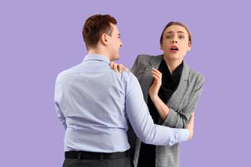 Business man grabbing his female colleague on lilac background. Harassment concept