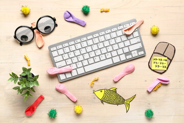 Funny glasses, computer keyboard and carton mouse on wooden background. April Fools Day prank