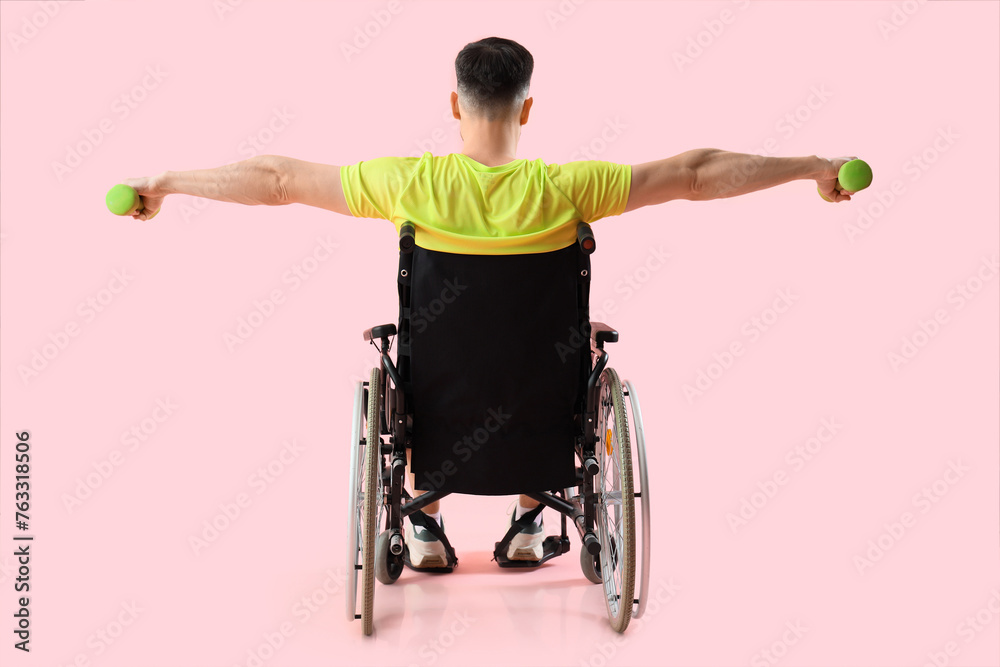 Poster Sporty young man in wheelchair with dumbbells on pink background, back view