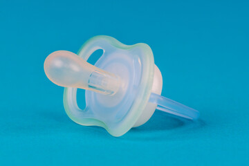 Baby blue pacifier on a blue background - 763320361