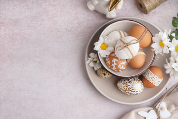 Fototapeta na wymiar Plates with decorated Easter eggs and spring flowers on white background