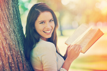 Tree, portrait and girl with novel to relax, book and fiction in nature of park outdoor. Adult,...