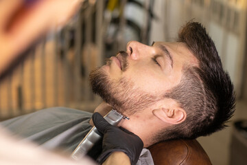 blond latin white man in a barbershop getting his hair cut with a beard in high resolution and high quality