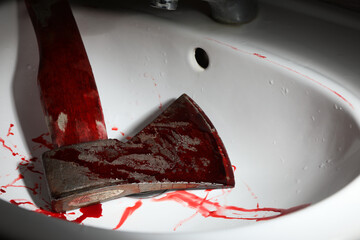 Axe with blood in sink, closeup view