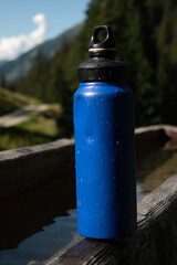 : Blue Water Bottle on Wooden Bench in Mountainous Landscape - 763332165