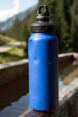: Blue Water Bottle on Wooden Bench in Mountainous Landscape - 763332174