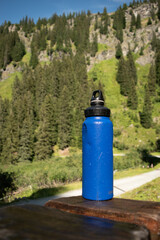 : Blue Water Bottle on Wooden Bench in Mountainous Landscape - 763332177
