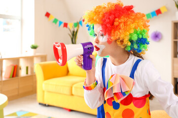 Funny little girl in clown costume with megaphone at home. April Fools' Day celebration - obrazy, fototapety, plakaty