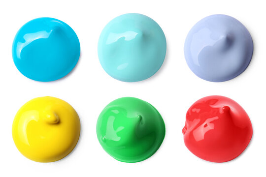 Paint blobs of different colors on white background, top view