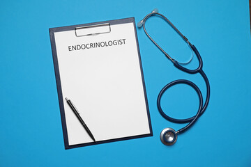 Endocrinologist. Clipboard, stethoscope and pen on light blue background, top view