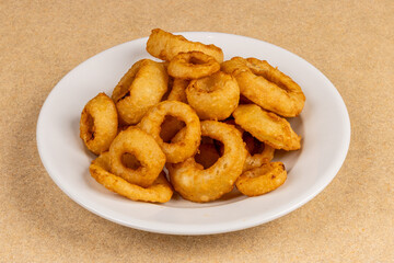 A plate of crispy deep fried onion rings or calamari rings