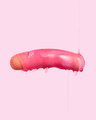 Sausage with dripping pink sauce on pink background.