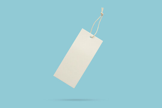 Blank price tag tied with string float on blue background