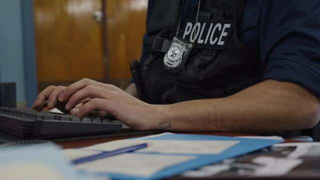 African american police officer typing paper work