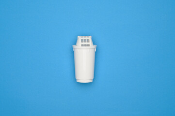 Layout: new filter cartridge for clean water on blue background, top view. Concept of household...