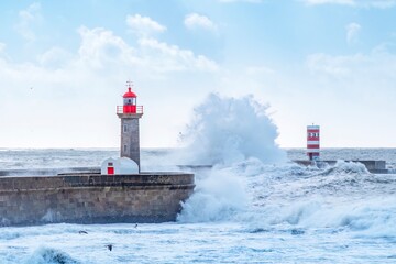 Storm waves over lighthouse, Portugal - sky enhanced. Windy coast. Bad weather with waves crashing in Porto harbor. - obrazy, fototapety, plakaty