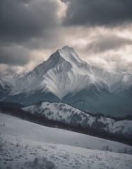 Fototapeta na wymiar Mountain covered in snow under a cloudy sky