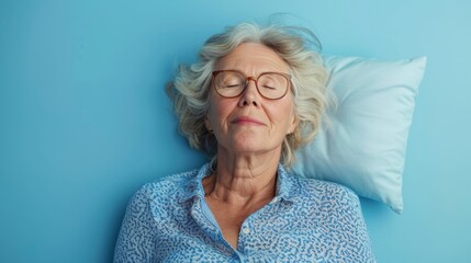 Elderly woman sleeping on pillow isolated on pastel blue colored background Sleep deeply peacefully rest. Top above high angle view photo portrait of satisfied .senior wear blue shirt - obrazy, fototapety, plakaty
