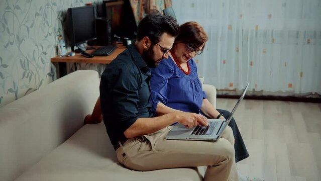 Grandmother and grandson uses online technology at home