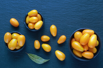 Fresh ripe kumquats  on dark table. Copy space
