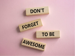 Do not forget to be Awesome symbol. Concept word Do not forget to be Awesome on wooden blocks. Beautiful pink background. Motivation concept. Copy space