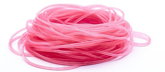 A pink thread close up and a group of hair ponytail rubber bands on white surface - obrazy, fototapety, plakaty