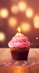 a pink cupcake with a candle in it, happy birthday concept