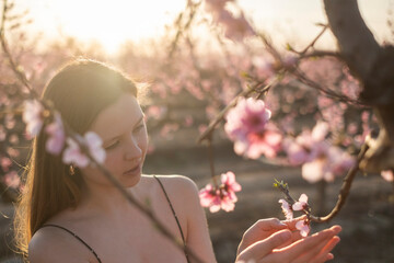 Mujer mirando las flores de los árboles melocotoneros