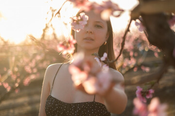 Mujer mirando las flores rosas del melocotonero