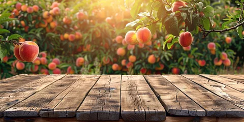 Poster Empty wooden kitchen table over peach fruit garden background © Ricardo Costa