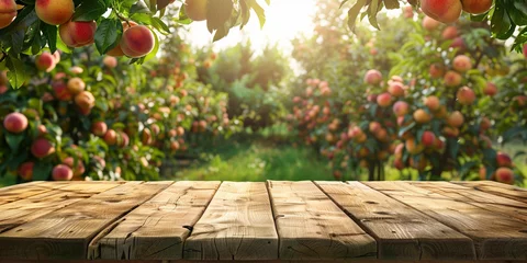 Tuinposter Empty wooden kitchen table over peach fruit garden background © Ricardo Costa