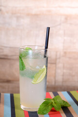 refreshing alcoholic drink with berries, ice vodka and gin, lemon peel served in glass cup on the counter on blurred background