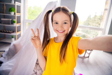Photo portrait of charming small girl take selfie video recording show v-sign wear trendy yellow...