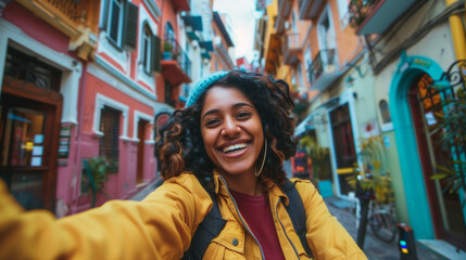 Fototapeta premium Joyful indian woman taking a selfie while exploring city streets during daytime