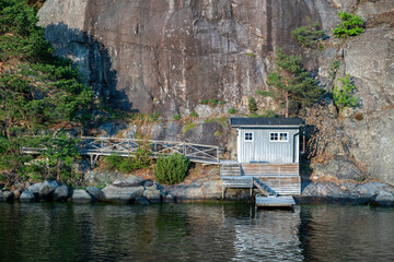 Fisherman hut, Sweden, Archipelago of Stockholm. Reflection in water of fishing cabin, rocky hill.