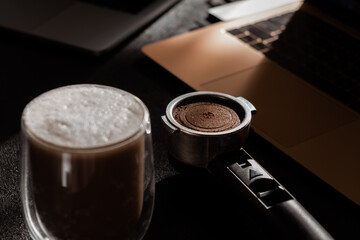 coffee on the desktop near the laptop . lunch at work