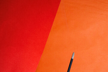 A closeup of a head of an  incense stick that comes to an end on the red orange background for...