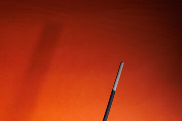 Fototapeta premium A fume and its shadow on the orange background