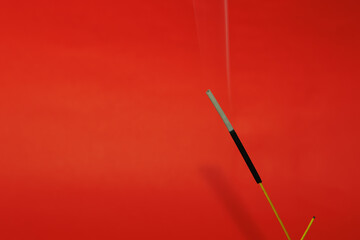 Fumigation and incense with fumes that one of them is used up on the red background