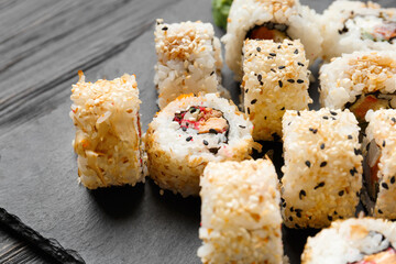 sushi rolls on a black slate plate, close-up.