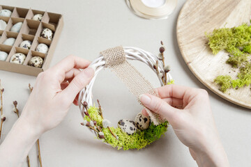 Florist at work: woman shows how to make simple Easter candle holder using a random glass and moss. Step by step, tutorial. - obrazy, fototapety, plakaty