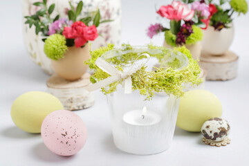 Florist at work: woman shows how to make simple Easter candle holder using a random glass and moss. Step by step, tutorial.